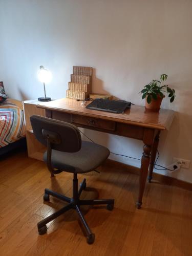 uma secretária de madeira com uma cadeira num quarto em Chambre chez l'habitant em Grenoble