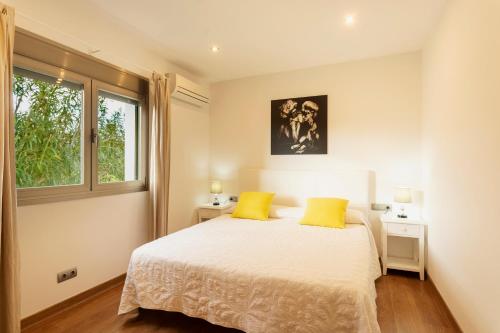 sypialnia z łóżkiem i 2 żółtymi poduszkami w obiekcie Villa con piscina Ibiza centro w mieście San Jose de sa Talaia