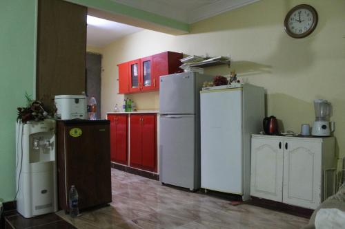 a kitchen with white appliances and red cabinets at Anhur Nubian Gest House in Naj‘ al Maḩaţţah