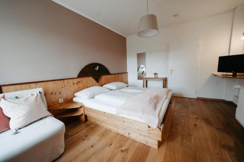 a bedroom with two beds and a flat screen tv at Hotel - Restaurant Soleo in Krumpendorf am Wörthersee