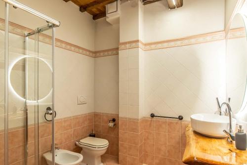 a bathroom with a toilet and a sink and a shower at Gattaia Apartments with swimming pool in Gattaia