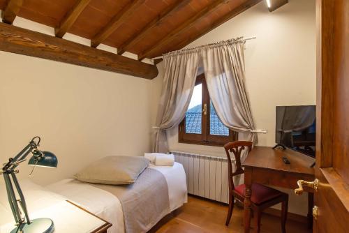 a bedroom with a bed and a desk with a computer at Gattaia Apartments with swimming pool in Gattaia