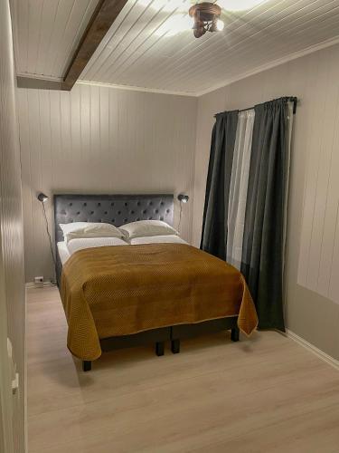 a bedroom with a large bed with a curtain at Villa Gulstua in Røros