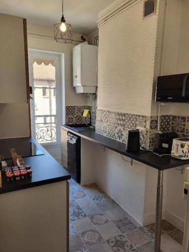 une cuisine avec un comptoir noir dans une pièce dans l'établissement Porte du Vieux Lyon 2, le long du quai, à Lyon