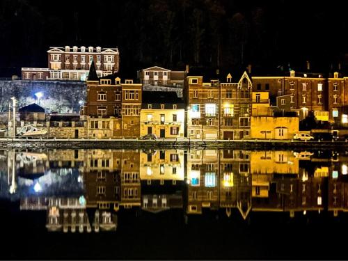 a city at night with its reflection in the water at AU PIED DE L'ABBAYE DE LEFFE in Dinant