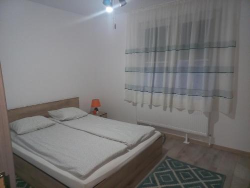 a small bedroom with a bed and a window at City Center Flat in Odorheiu Secuiesc
