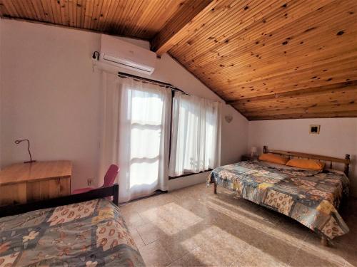 a bedroom with two beds and a large window at Villa Sofia in Chernomorets