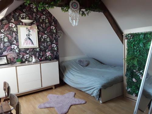 a room with a bed and a wall with flowers at Chaleureuse fermette à proximité du circuit des 24h du MANS in Ruaudin