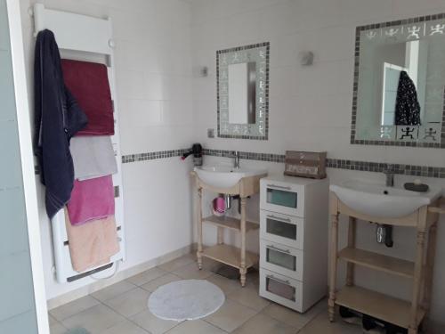 a bathroom with two sinks and a mirror at Chaleureuse fermette à proximité du circuit des 24h du MANS in Ruaudin