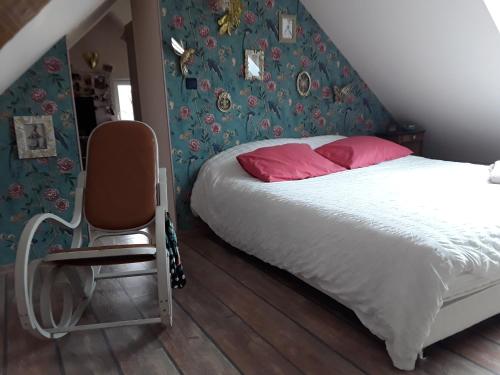 a bedroom with a bed and a chair in it at Chaleureuse fermette à proximité du circuit des 24h du MANS in Ruaudin