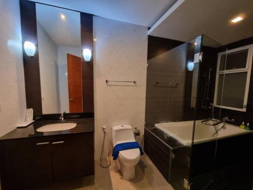 een badkamer met een toilet, een wastafel en een spiegel bij ChinJu PoolVilla in Jomtien Beach