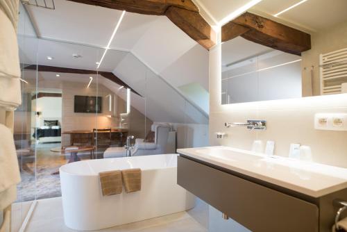 a bathroom with a white tub and a sink at Hof de Draeck Bed & Breakfast in Teuven