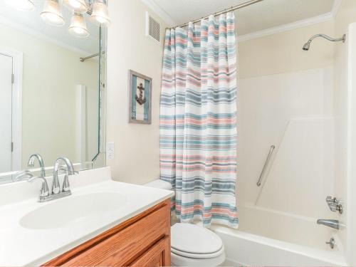 a bathroom with a sink and a toilet and a shower at Beach Racquet A127 in Tybee Island