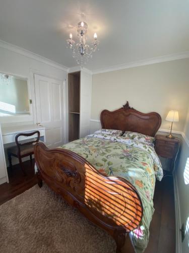 1 dormitorio con cama de madera y lámpara de araña en NEW LISTING Faye’s Place, en Donegal