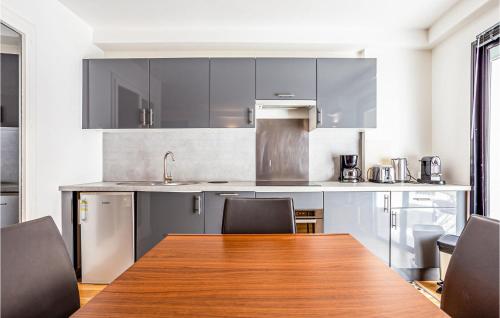 une grande cuisine avec une table et des chaises en bois dans l'établissement 1 Bedroom Amazing Apartment In Cannes, à Cannes