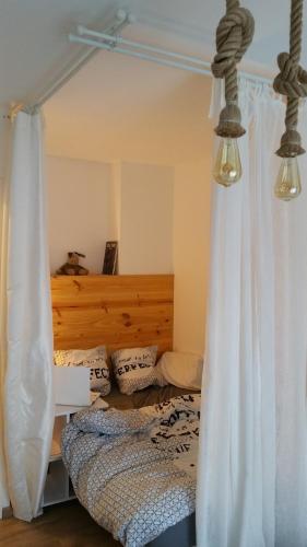 a bedroom with a bed with white curtains at Cosy Nest in Limoges