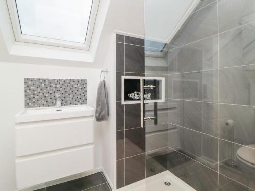 een badkamer met een douche en een wastafel bij Ingledene in Brixham