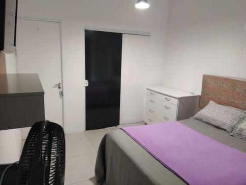 1 dormitorio con 1 cama, vestidor y escritorio en CASA TEMPORADA NO PÂNTANO DO SUL, en Florianópolis