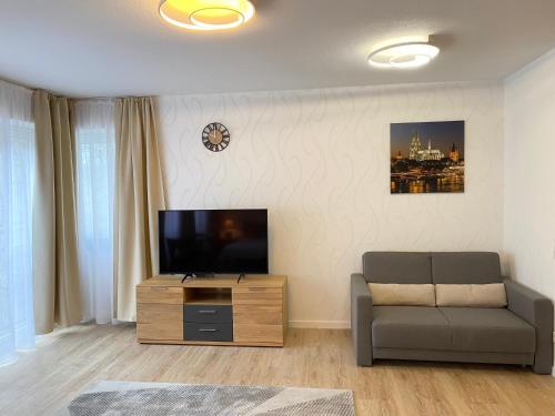 a living room with a couch and a flat screen tv at Sehr zentral, geräumiges, helles Studio-Apartment in Cologne