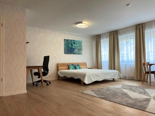 Schlafzimmer mit einem Bett und einem Schreibtisch mit einem Computer in der Unterkunft Sehr zentral, geräumiges, helles Studio-Apartment in Köln