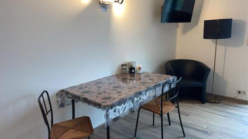 mesa de comedor con sillas y TV en Au Trouli, en Verviers