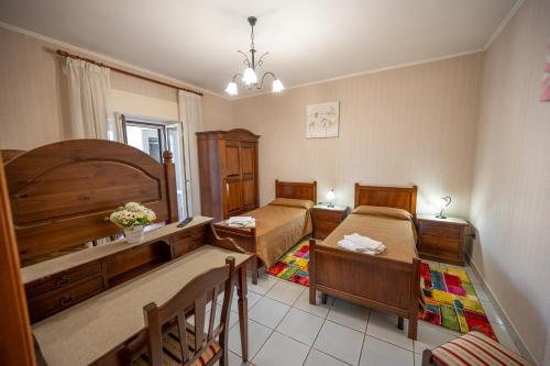 1 Schlafzimmer mit 2 Betten, einem Tisch und Stühlen in der Unterkunft Agriturismo Caperroni in Pescopagano