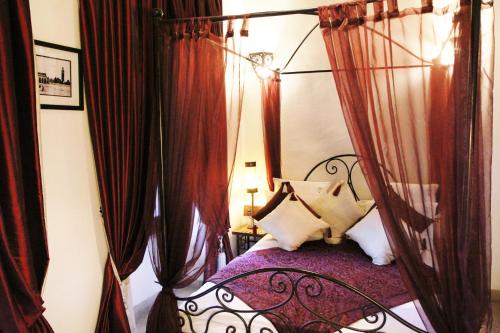 a bedroom with a canopy bed with red curtains at Riad Terra Bahia in Marrakech