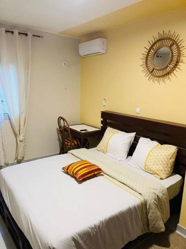 a bedroom with a large bed and a mirror at Résidence Karamel Yaoundé Anguissa in Yaoundé