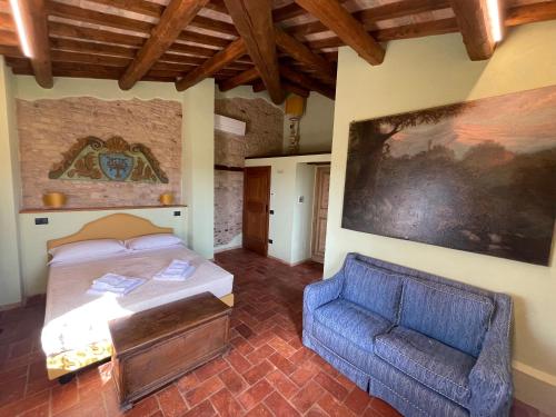 um quarto com uma cama e um sofá azul em Corte Landriani em Montefelcino