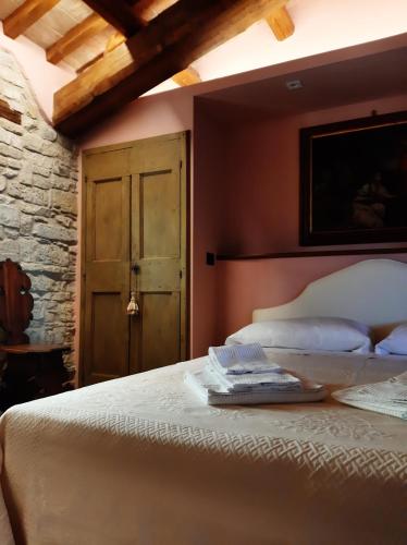 a bedroom with a white bed with a wooden ceiling at Corte Landriani in Montefelcino