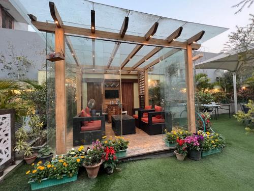 un jardín con pérgola y una sala de estar. en GREEN HOME STAY, en Lucknow