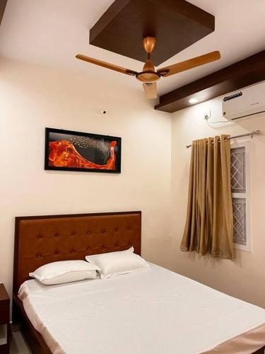 a bedroom with a bed and a ceiling fan at Izi Airport Stay in Chennai
