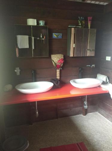two sinks on a red counter in a bathroom at playa mecana kirita in Bahía Solano