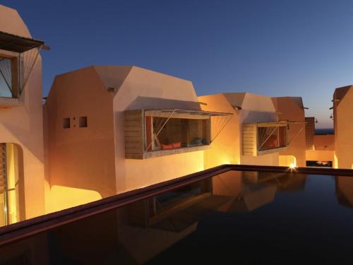 a building with a swimming pool in front of it at Hotel Dar Hi in Nefta