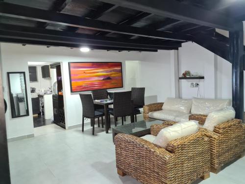 ein Wohnzimmer mit einem Sofa und einem Tisch in der Unterkunft Cabaña los Abuelos in Coveñas