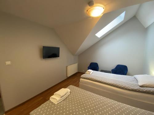 a attic bedroom with two beds and a tv at Restauracja Zacisze Leśne Noclegi in Knurów
