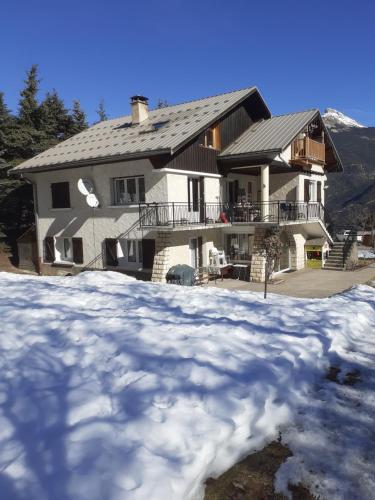 een groot huis met sneeuw ervoor bij La Grande Lauze in Champcella