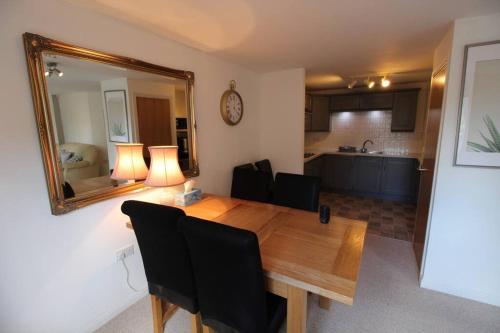 mesa de comedor con sillas negras y espejo en 3 bedroom flat 10 mins walk to Bay and City center Free Parking en Cardiff