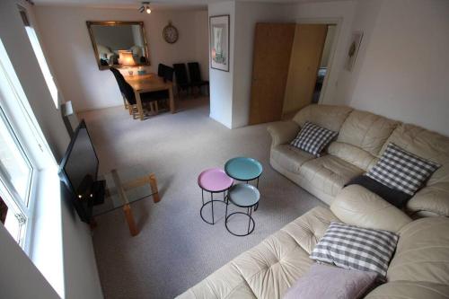 een woonkamer met een bank en een tafel bij 3 bedroom flat 10 mins walk to Bay and City center Free Parking in Cardiff