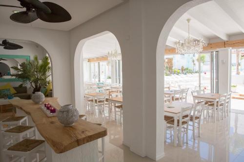 een eetkamer met tafels en stoelen en een kroonluchter bij Beach Star Adults Only Party Hotel Ibiza in San Antonio Bay