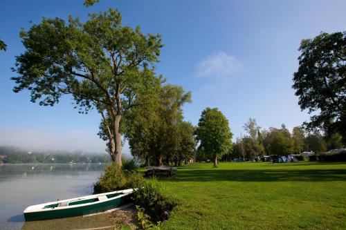 a boat sitting on the grass next to a lake at Romantik Hotel Chalet am Kiental in Herrsching am Ammersee