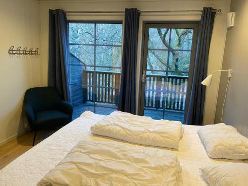 1 dormitorio con 1 cama, 1 silla y 1 ventana en Øvstefjellså Gård &Aktivitet Senter en Flekkefjord