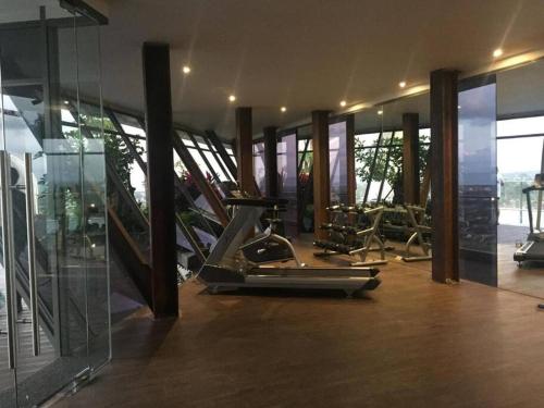 a gym with several treadmills and elliptical machines at Apartemen Uttara with Mountain View City Center in Kejayan