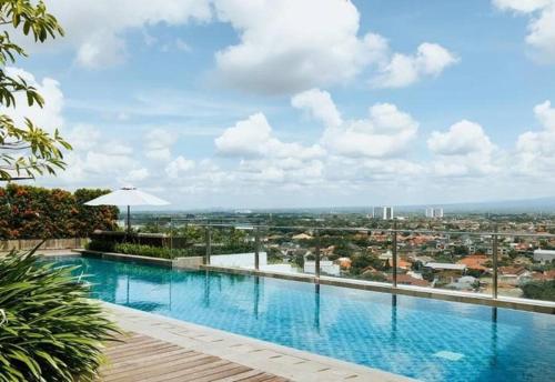 a swimming pool on top of a building at Apartemen Uttara with Mountain View City Center in Kejayan