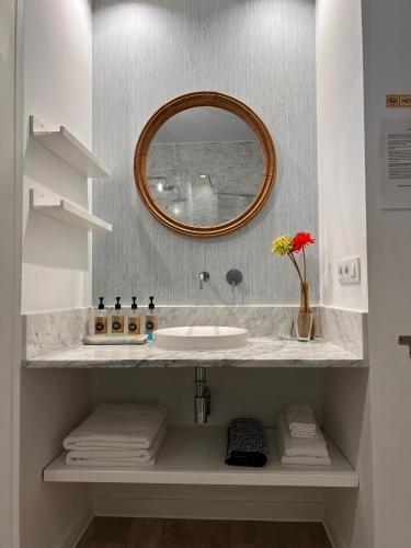 a bathroom with a sink and a mirror at Chipibeach B&B, Hostal Boutique in Chipiona
