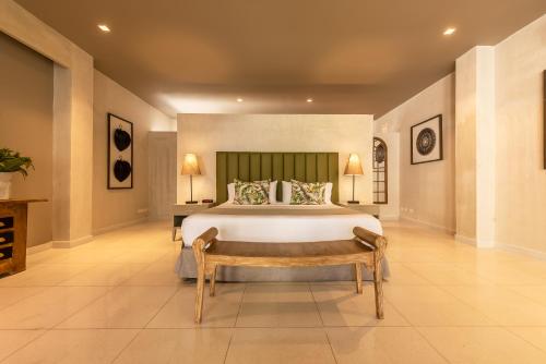 a large bedroom with a large bed and a bench at Madisson Boutique Hotel Cartagena in Cartagena de Indias
