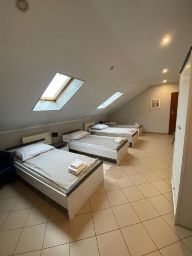 a row of beds in a room with skylights at Restauracja Zacisze Leśne Noclegi in Knurów