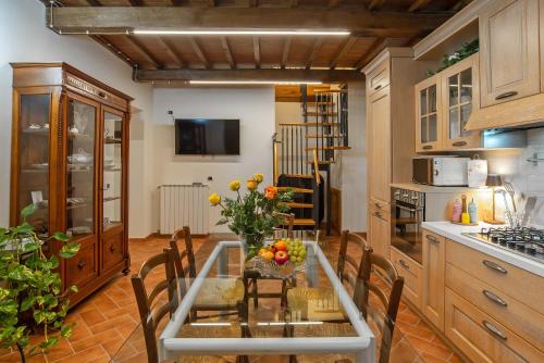 a kitchen with a glass table and chairs in a kitchen at Gattaia Apartments with swimming pool in Gattaia
