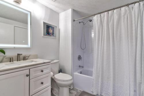 y baño blanco con aseo y ducha. en The DMV Creative Home en Arlington