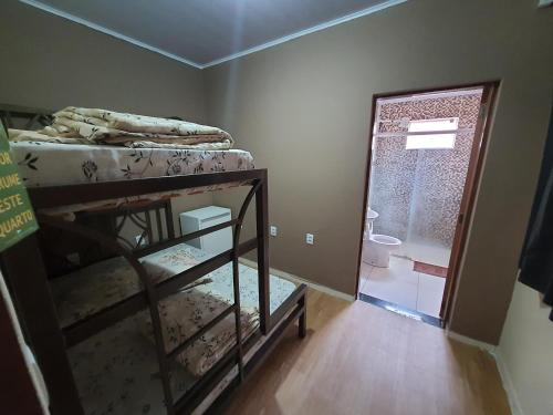 a room with a bunk bed and a bathroom at Pousada Pimenta Olimpia in Olímpia